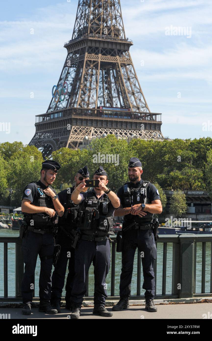 Im Zuge der Paralympischen Spiele 2024 in Paris wurde eine große Zahl von Polizisten auf den Straßen von Paris eingesetzt. Einige Polizisten nehmen sich einen Moment Zeit, um ein Selfie vor dem Eiffelturm zu schnappen, das mit den Olympischen Ringen vor der Eröffnung der Paralympischen Spiele 2024 in Paris glänzt. Dies ist das erste Mal, dass Frankreich die Paralympics ausrichtet. Veranstaltungen finden an berühmten Orten wie dem Eiffelturm, den Champs-Elysées und der seine statt und verbinden Sport mit der Schönheit von Paris. Im Laufe von elf Tagen wurden 4.400 Elite-Athleten aus der ganzen Welt Stockfoto