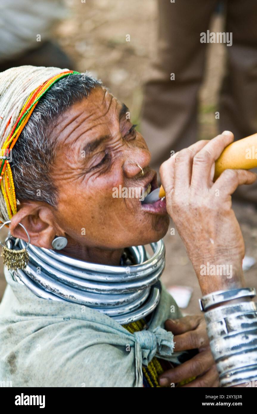 Eine Bonda-Stammesfrau, die ein Kleinkind aus einem getrockneten Kürbis trinkt. Malkangiri, Odisha, Indien. Stockfoto
