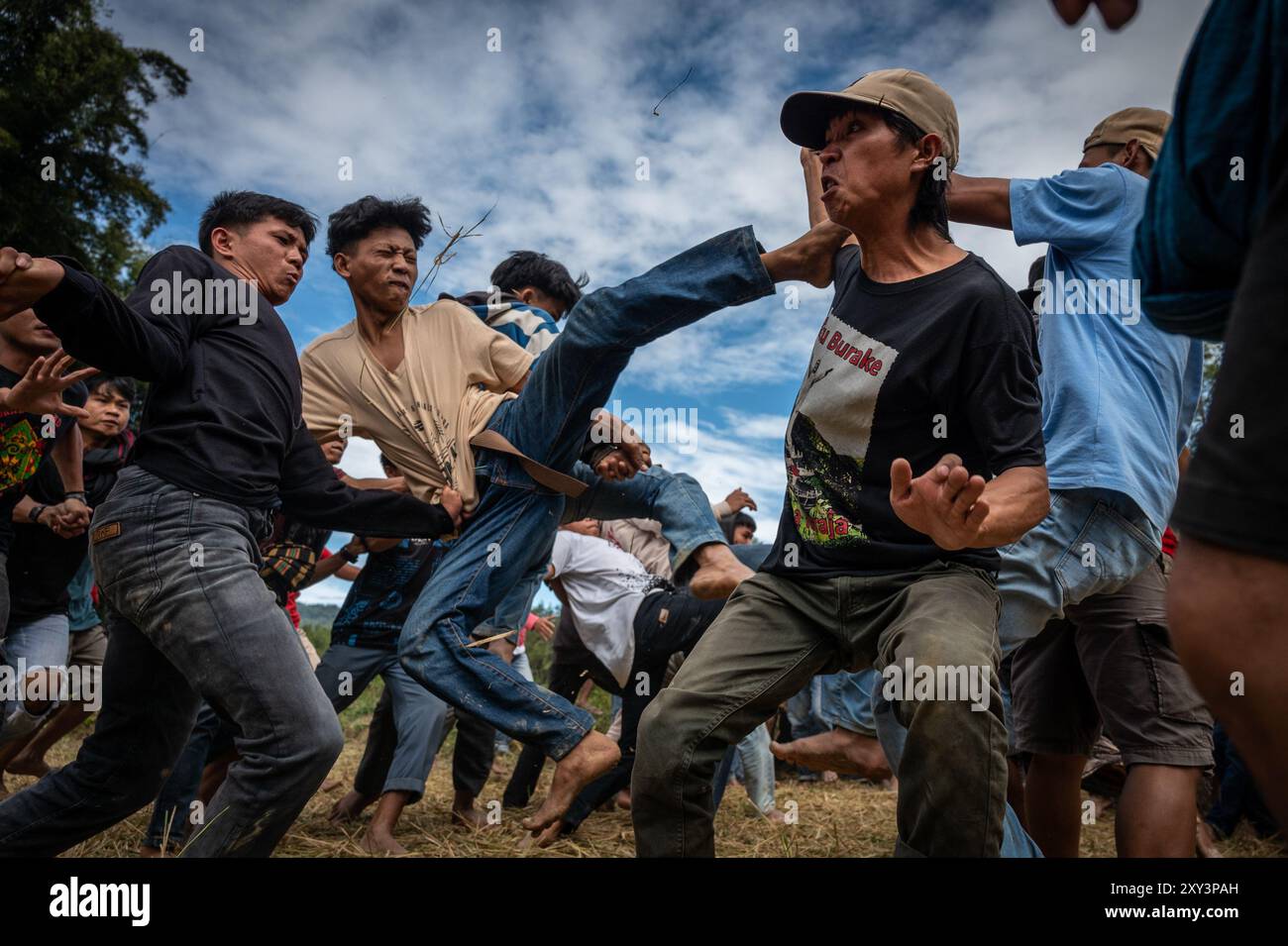 Toraja Utara, Süd-Sulawesi, Indonesien. August 2024. Einige Männer treten sich gegenseitig, während sie an der Sisemba-Tradition in Panggala teilnehmen. Die Tradition ist ein Ausdruck der Dankbarkeit für die Kulturen und basiert auf der Überzeugung, dass die Veranstaltung sie für die bevorstehenden Arbeiten begeistern wird, um die nächsten reichlichen Ernten zu erhalten. Ohne Sisemba zu spielen, glauben die Leute von Tana Toraja, dass es zu Ernteversagen kommen wird. Die Tradition soll Verwandtschaftswerte aufrechterhalten. Teilnehmer, die gefallen sind, dürfen nicht angegriffen werden, und Personen, die in Sissis verletzt werden Stockfoto