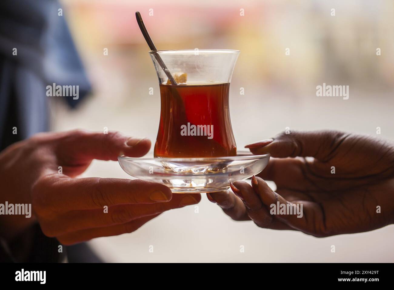 Hände halten ein Glas türkischen Tee aus Stockfoto