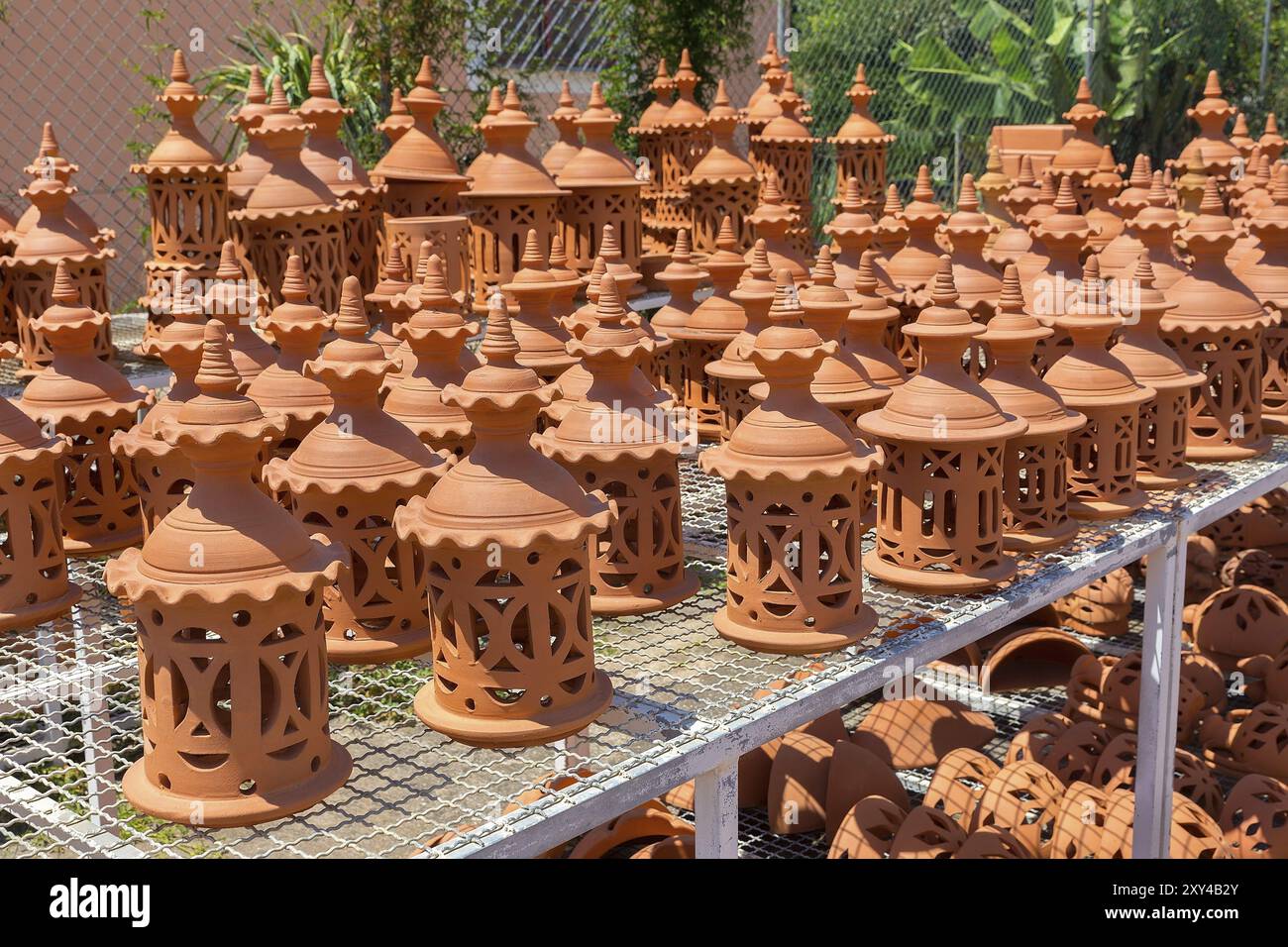 Viele orangefarbene Tontöpfe auf dem Regal im Töpferladen Stockfoto