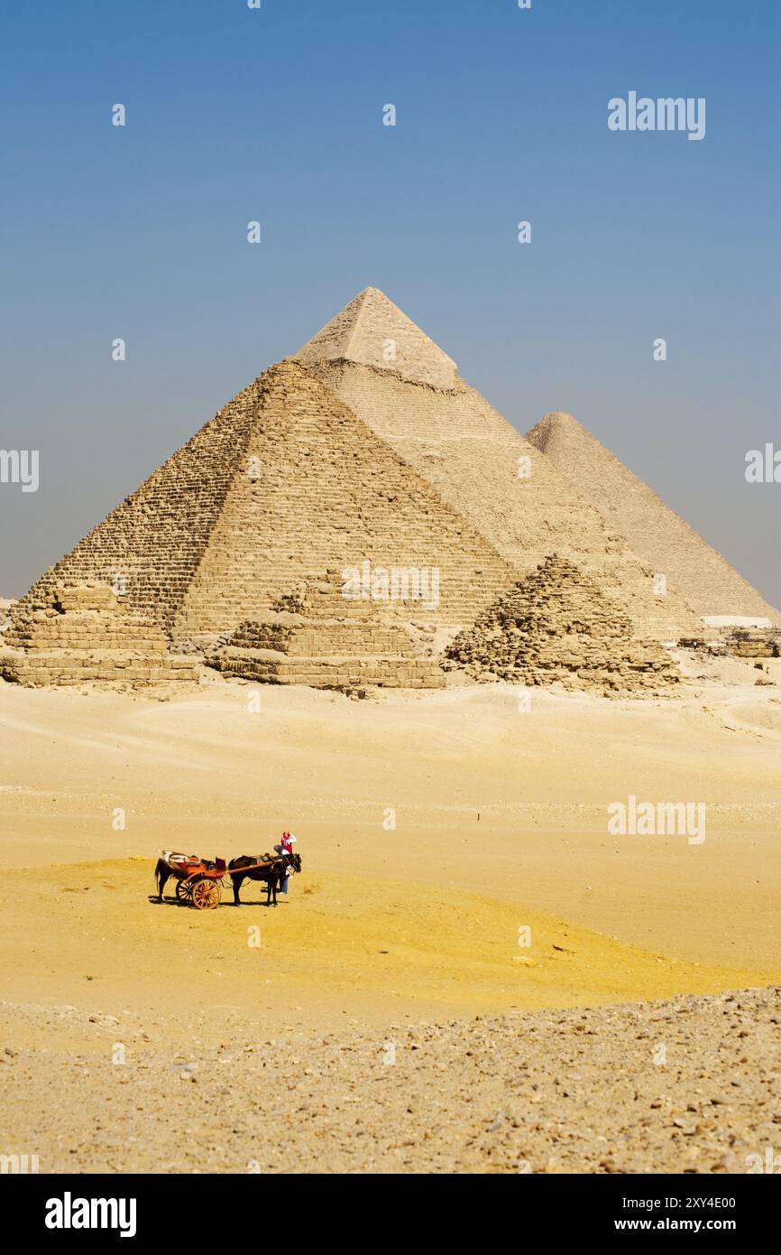 Eine Gruppe nicht erkennbarer ägyptischer Touristen steigt von ihrem Pferdewagen ab, um alle Pyramiden von Gizeh in einer Schlange zu sehen Stockfoto