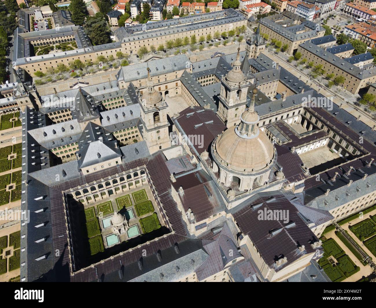 Historisches Kloster aus der Luft, mit einem zentralen Innenhof und umgeben von der Stadt, aus der Luft, Real Sitio de San Lorenzo de El Escorial, Roya Stockfoto