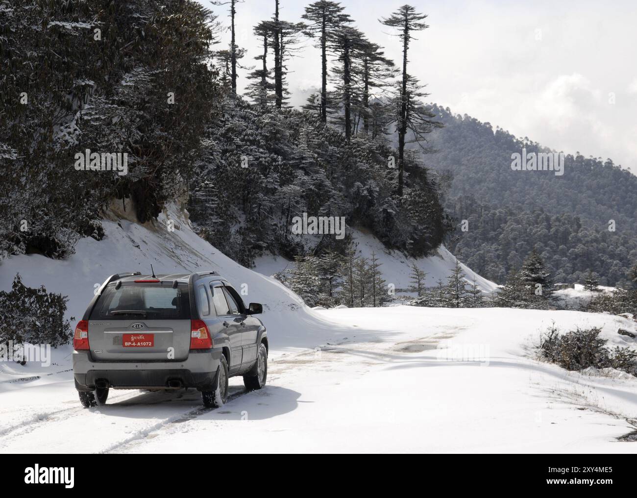 Auto fahren in den Schnee am Thrumshingla-Pass, der Grenze zwischen Mittel- und Osteuropa Bhutan Stockfoto