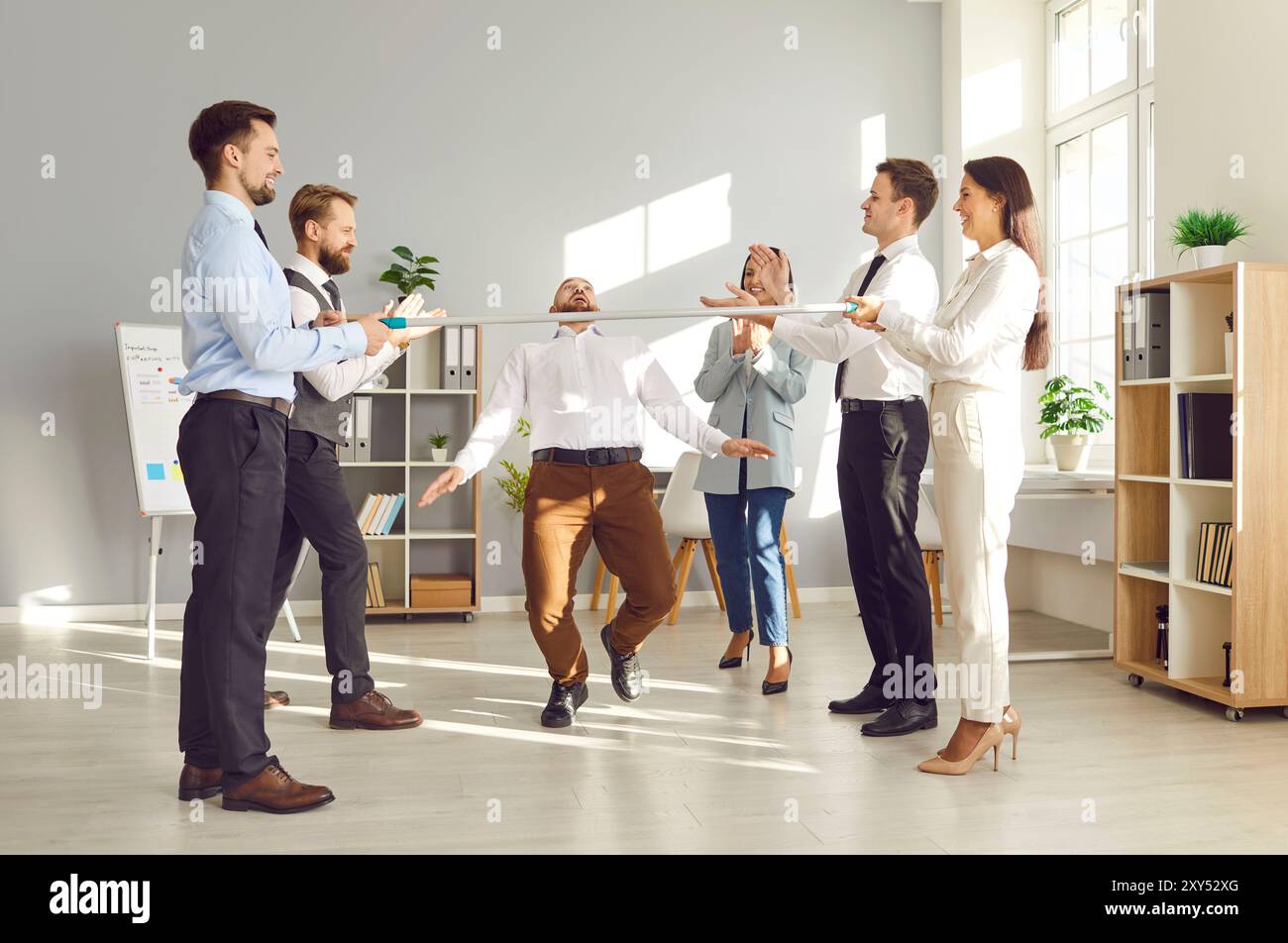 Büroangestellte Spielen Limbo Und Tanzen Auf Der Office Party Stockfoto