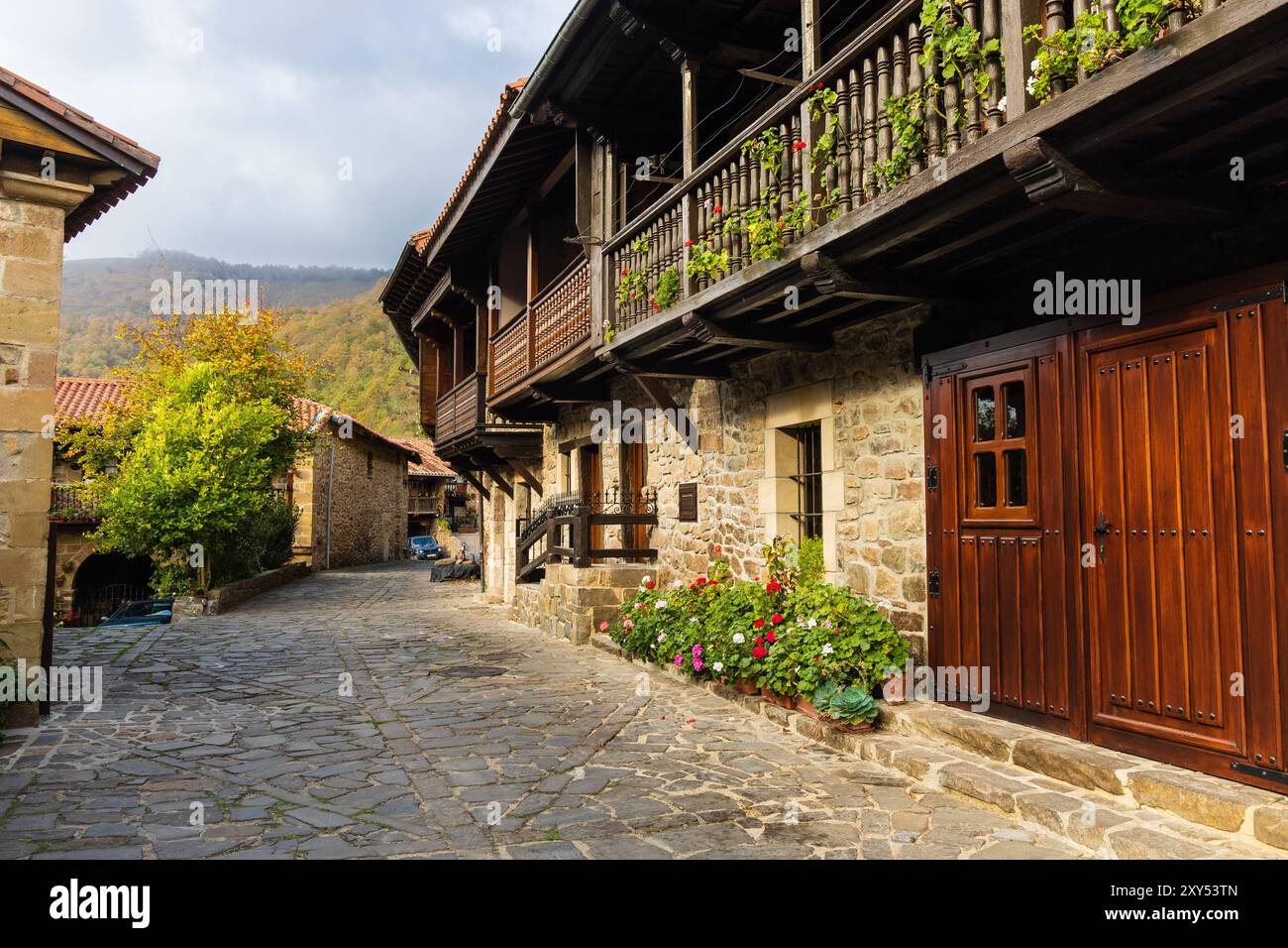 Straßen- und ländliche Berghäuser mit breiten Veranden und Holzgehegen mit Blumen. Bárcena Bürgermeister, Kantabrien, Spanien. Stockfoto