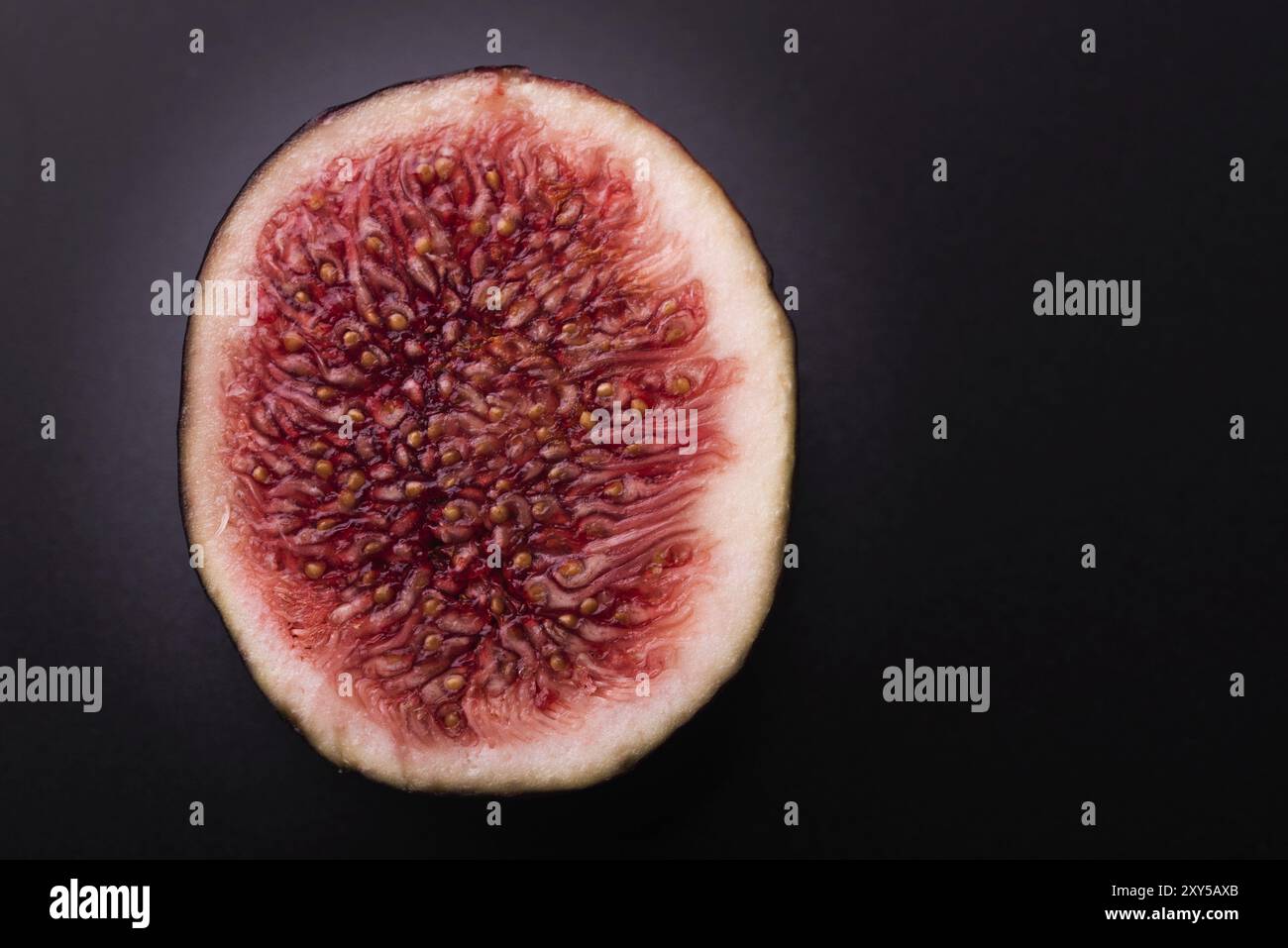 Halbfrische Feige auf schwarzem Grund isoliert einschneiden. Detailreiche Makroaufnahmen. Speicherplatz kopieren Stockfoto