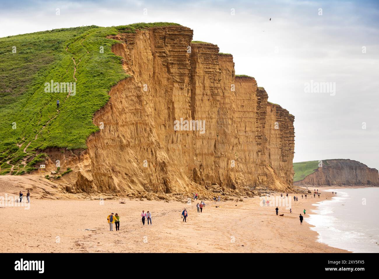 Großbritannien England, Dorset, Bridport, West Bay, Besucher am Strand unterhalb der Klippen, die vor kurzem einen Felssturz erlebten Stockfoto