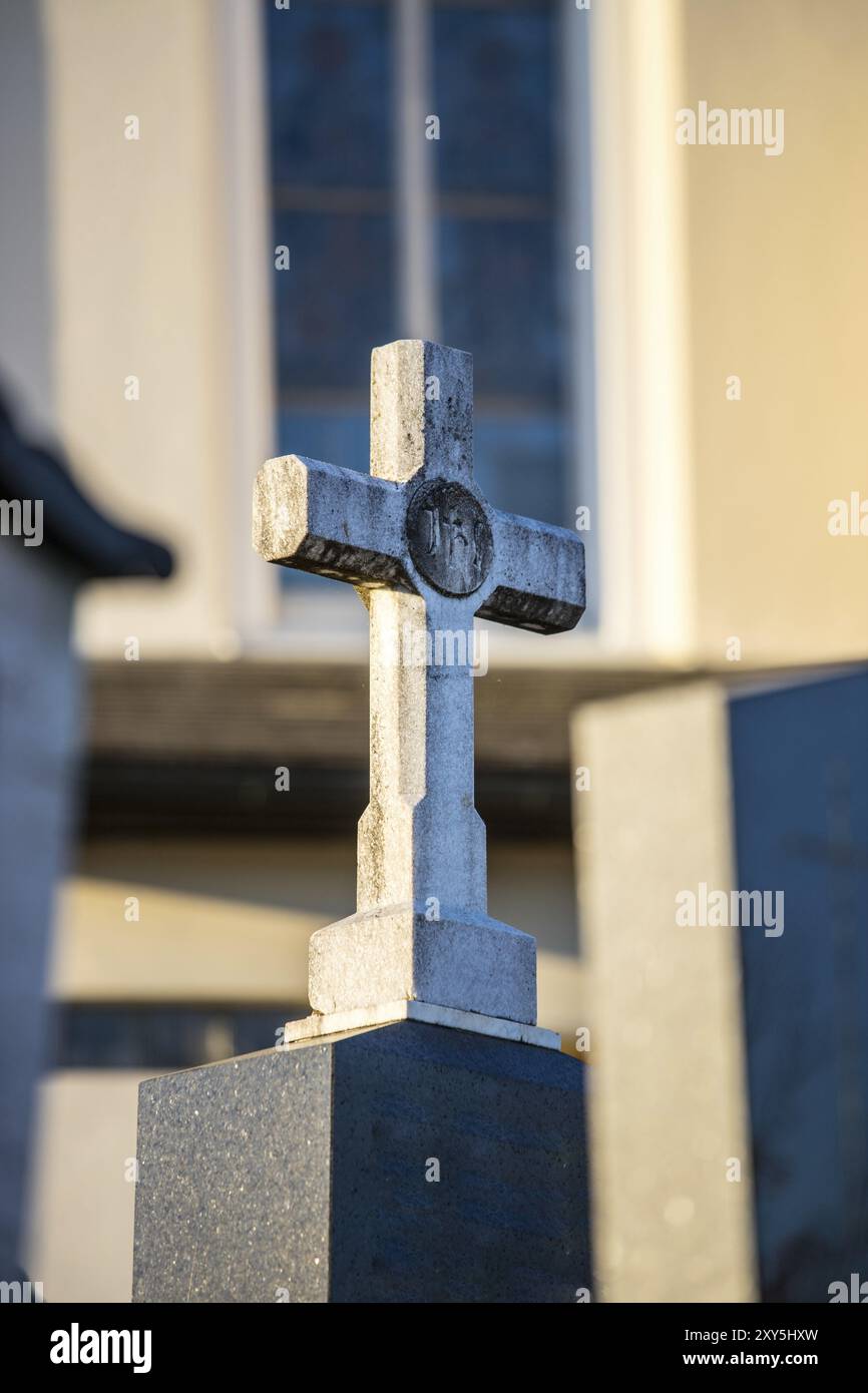 Weißer Stein Kreuz auf einem Grab, Abendsonne Stockfoto