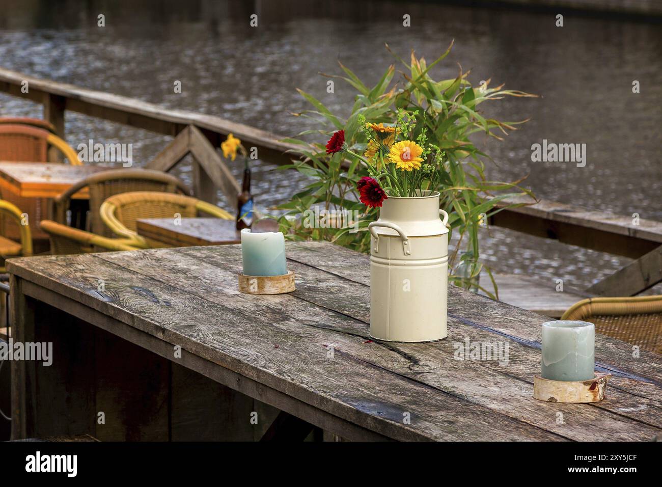 Gemütliches Straßencafé Holztisch mit Blumen in Vase. Einrichtung im Freien mit Kerzen in den Niederlanden Stockfoto