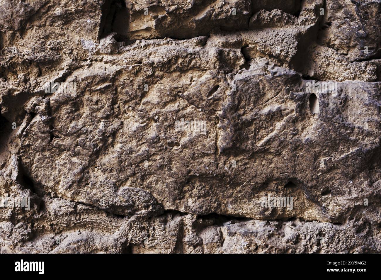 Schließen Sie große Steine in mittelalterlichem Mauerwerk strukturierter Hintergrund einer Mauer aus mittelalterlichem Mauerwerk. Die Mauer ist schlampig und aus Bergsteinen gebaut. Mediev Stockfoto