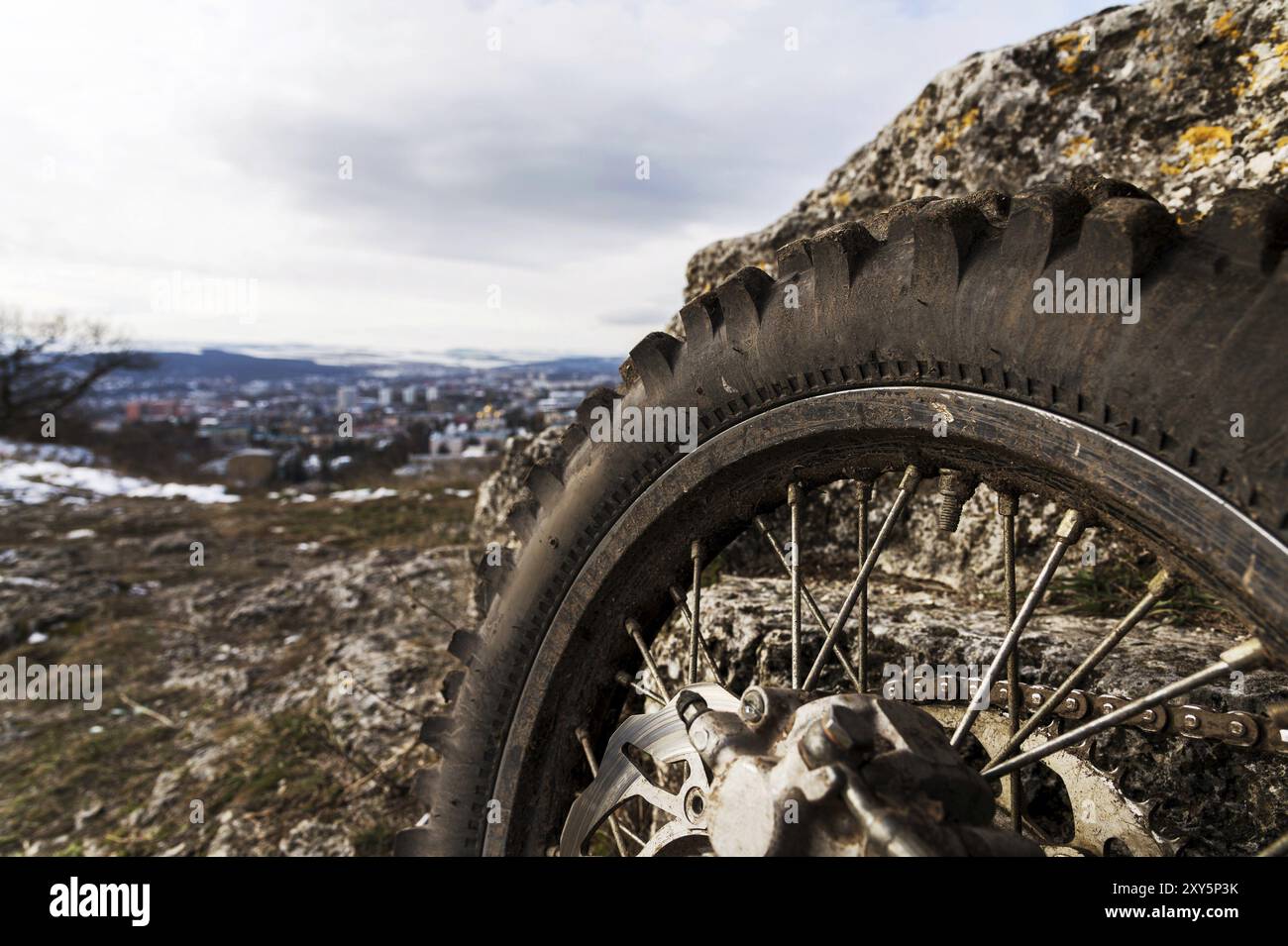 Rad mit Speichen und Bremsscheibe plus Enduro Motorradkette. Nahaufnahme im Hintergrund einer Landschaft Stockfoto