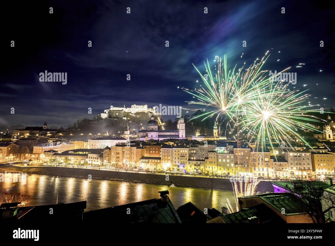 Buntes Feuerwerk in der Nacht: Altstadt von Salzburg und Festung Hohensalzburg an Silvester. Magie Stockfoto