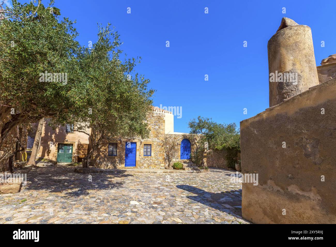 Monemvasia, Peloponnes, Griechenland Straßenblick mit alten Häusern mit blauen Türen Stockfoto