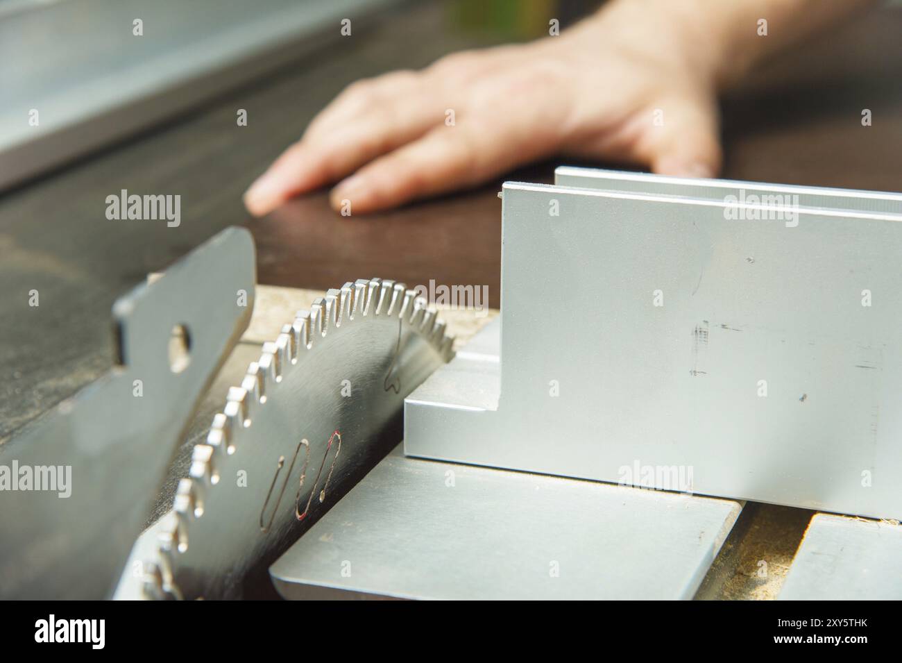 Nahaufnahme eines Sägeblattes einer Kreissägeblattmaschine und Hand eines Zauberers Stockfoto