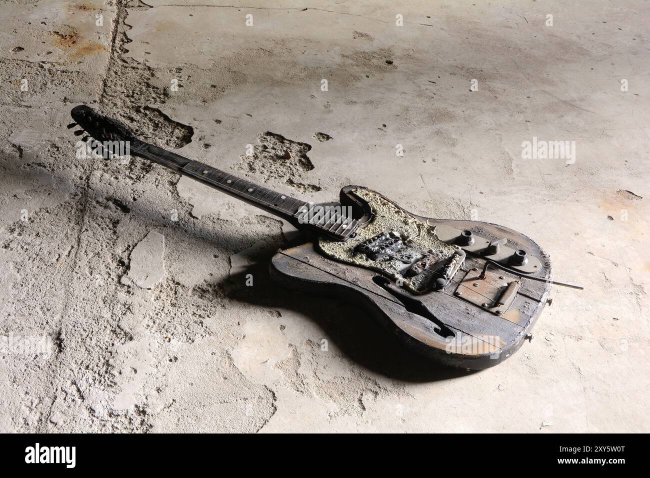 Verbrannte Gitarre auf dem Boden eines verlassenen Hauses in Magdeburg Stockfoto