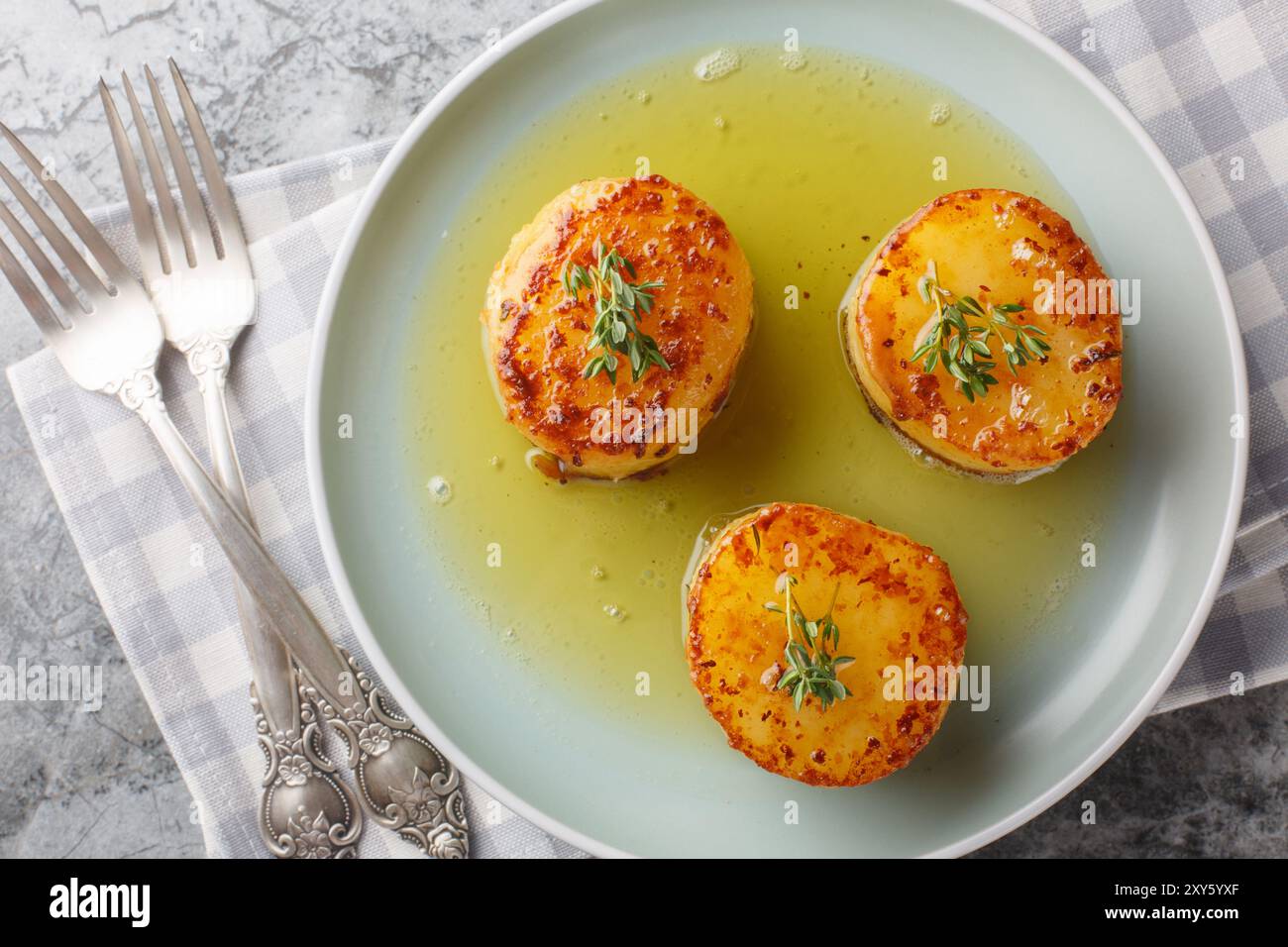 Schmelzende Kartoffeln, geschmort mit Butter, Brühe, Knoblauch und frischen Kräutern, die einen Löffel cremige Aromen aus der Nähe auf dem Teller auf dem Tisch erzeugen. Horizont Stockfoto