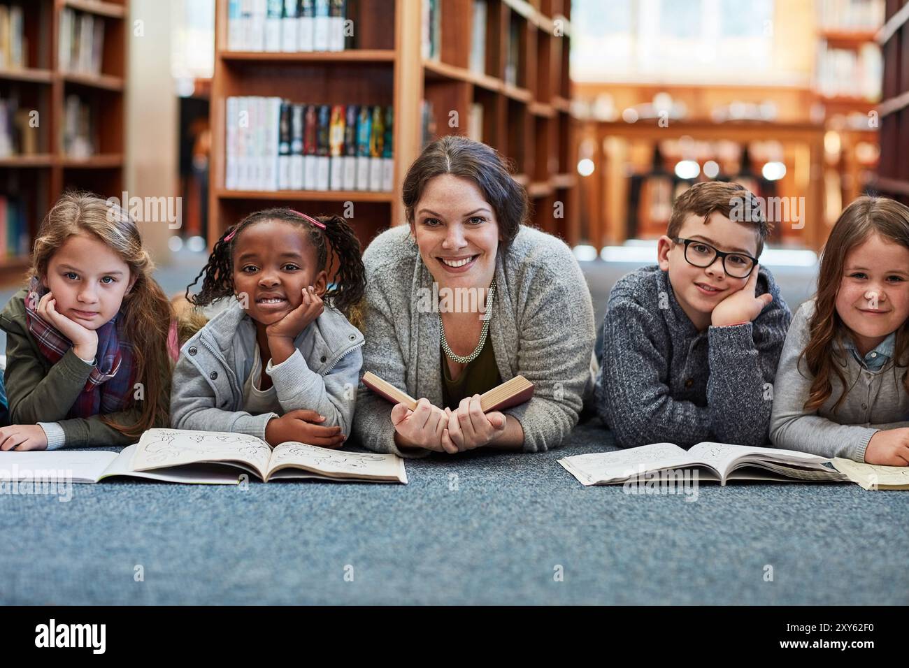 Frau, Bibliothek und Lesebuch für Kinder im Porträt, Bildung und Fantasy-Literatur-Fiktion. Person, Bibliothekar freiwillig und Geschichtenerzähler Stockfoto