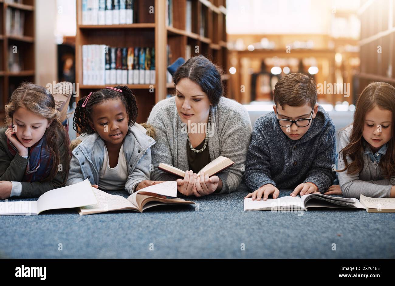 Frau, Lehrerin und Vorlesung für Kinder in Bibliothek, Bildung und Fantasy-Literatur-Fiktion. Weibliche Person, Bibliothekarin Freiwillige und Geschichten erzählen Stockfoto