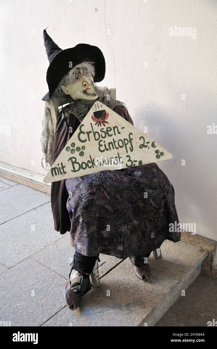 Eine Hexe präsentiert das Angebot des Tages an einer Snackbar Stockfoto