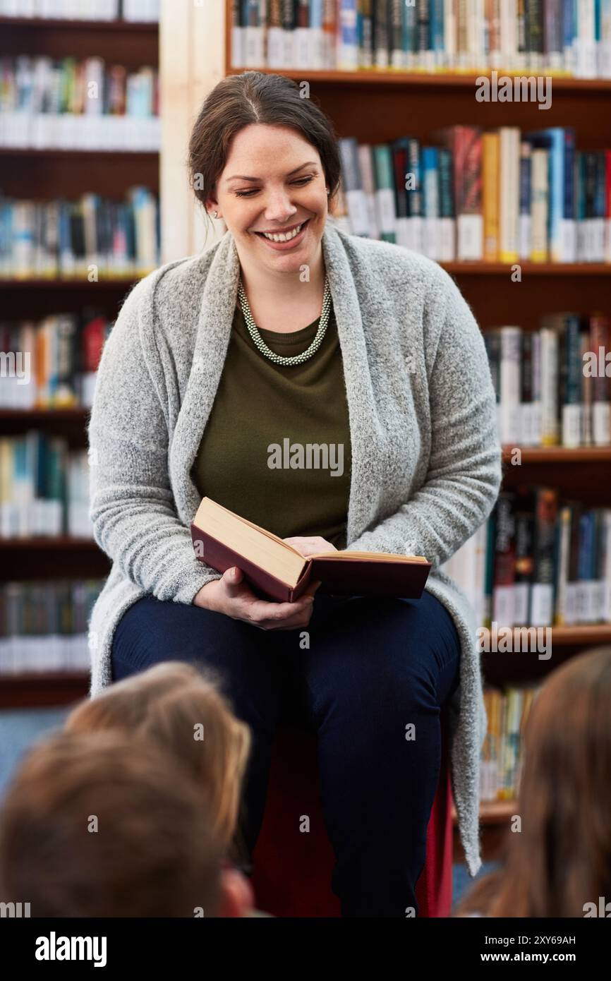 Frau, Lehrerin und Lesebuch für Kinder in Bibliothek, Bildung und Fantasy-Literatur-Fiktion. Weibliche Person, Bibliothekarin Freiwillige und Geschichten erzählen Stockfoto