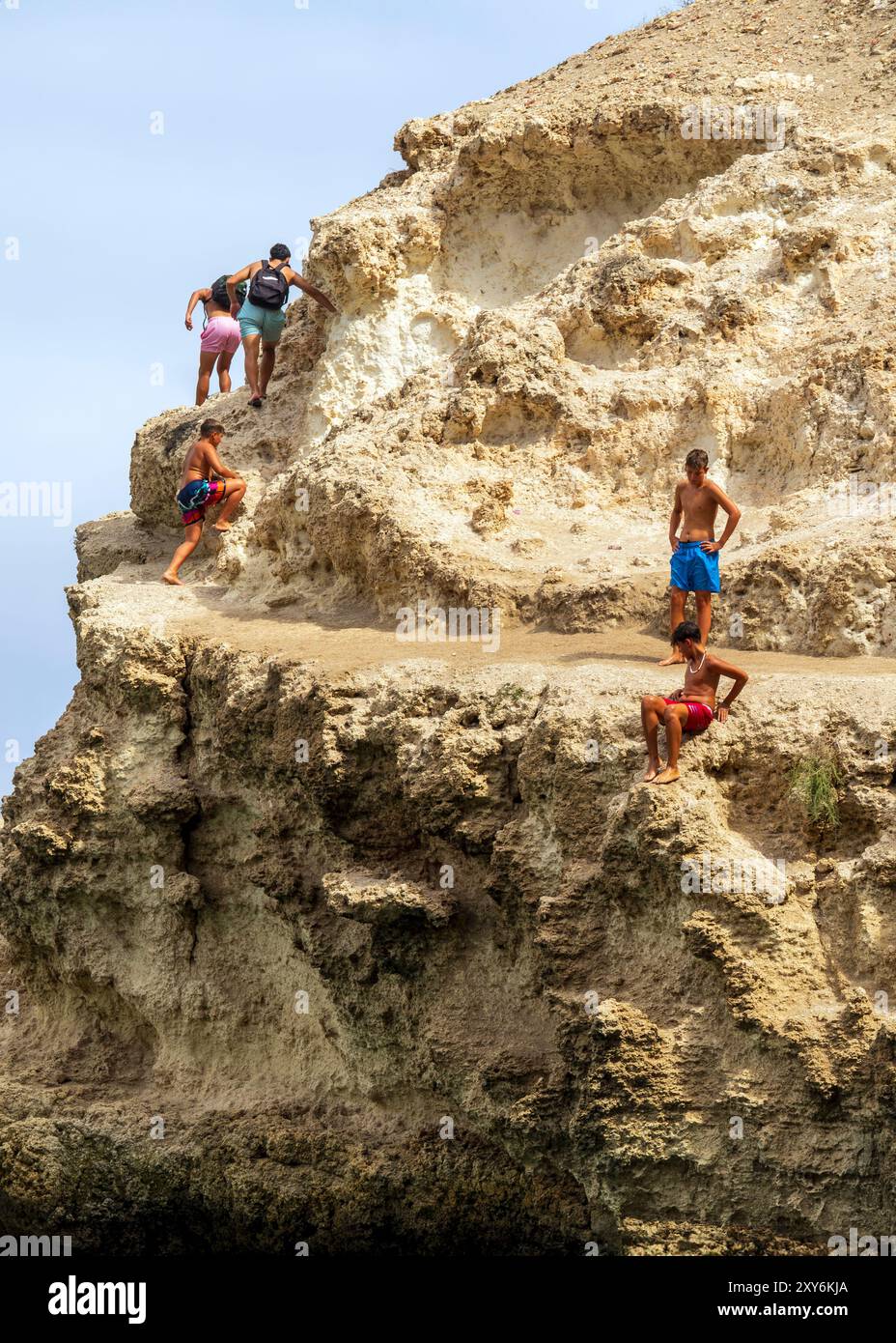 08/09/2024. Melilla, Spanien. Kinder spielen auf den Klippen rund um die Küste von Melilla la Vieja in der autonomen Stadt Melilla, Spanien. Stockfoto