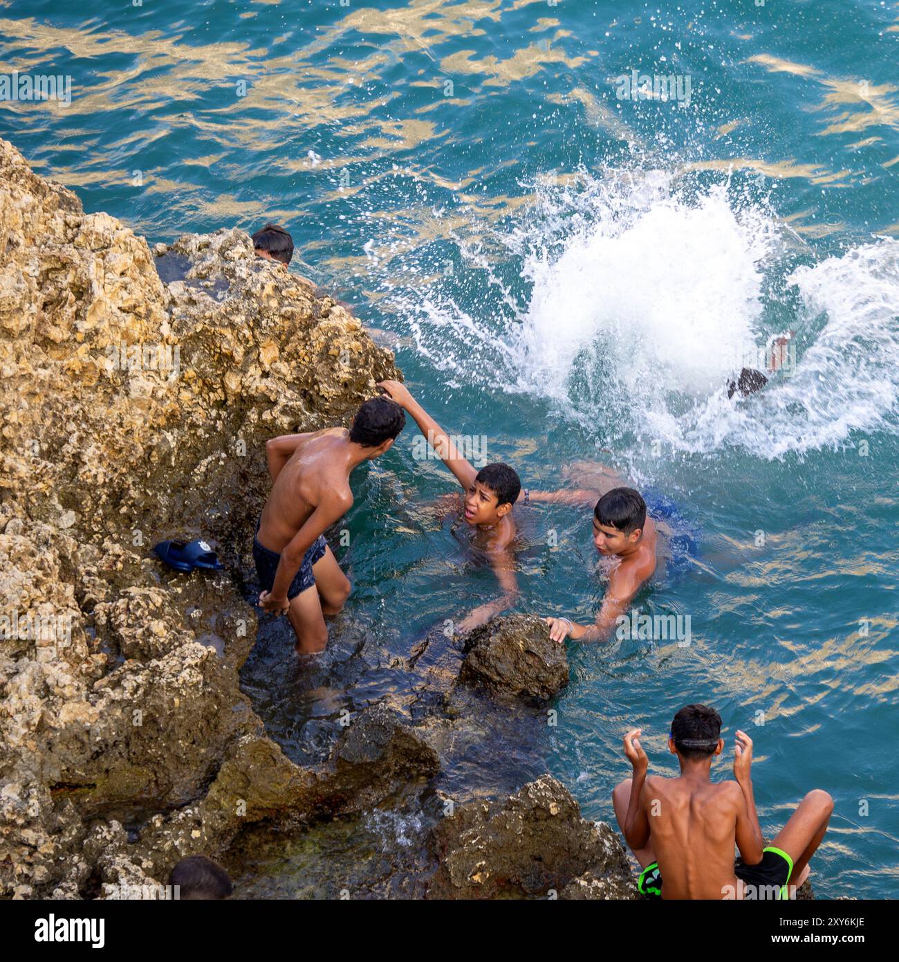 08/09/2024. Melilla, Spanien. Kinder spielen auf den Klippen rund um die Küste von Melilla la Vieja in der autonomen Stadt Melilla, Spanien. Stockfoto