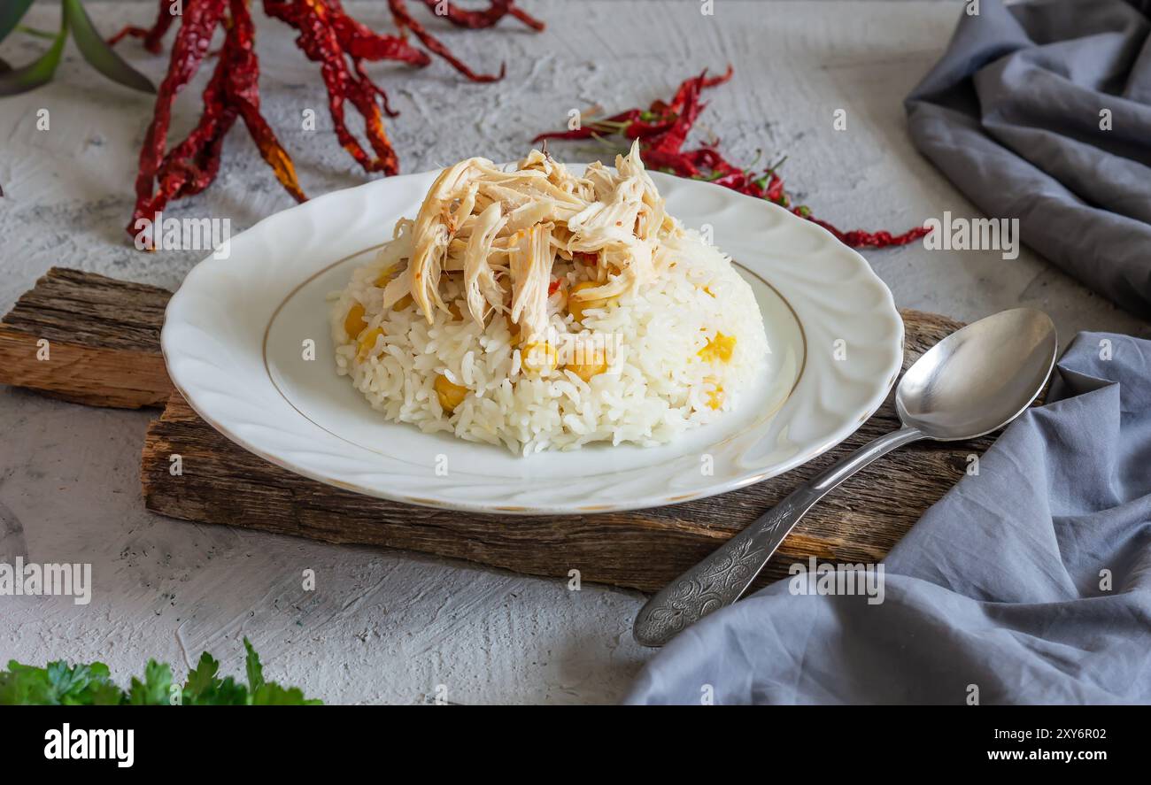 Traditionelles türkisches Essen, Hähnchenpilaw, Reis mit Kichererbsen auf Teller auf rustikalem Hintergrund Stockfoto