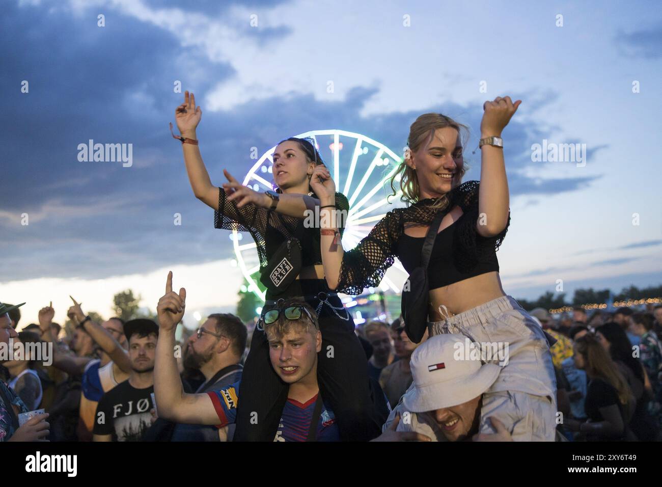 Festivalbesucher feiern auf Schultern bei Ski Aggu's Vorstellung vor dem Riesenrad beim Highfield Festival am Samstag, Stoermthale Stockfoto