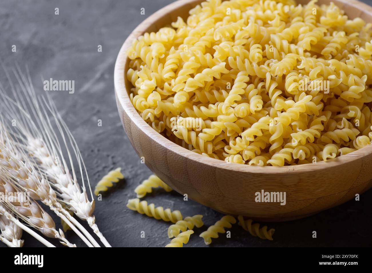 Rohe Schneckennudeln in Schüssel oder Löffel, ungekochte Fusilli mit Weizen Stockfoto