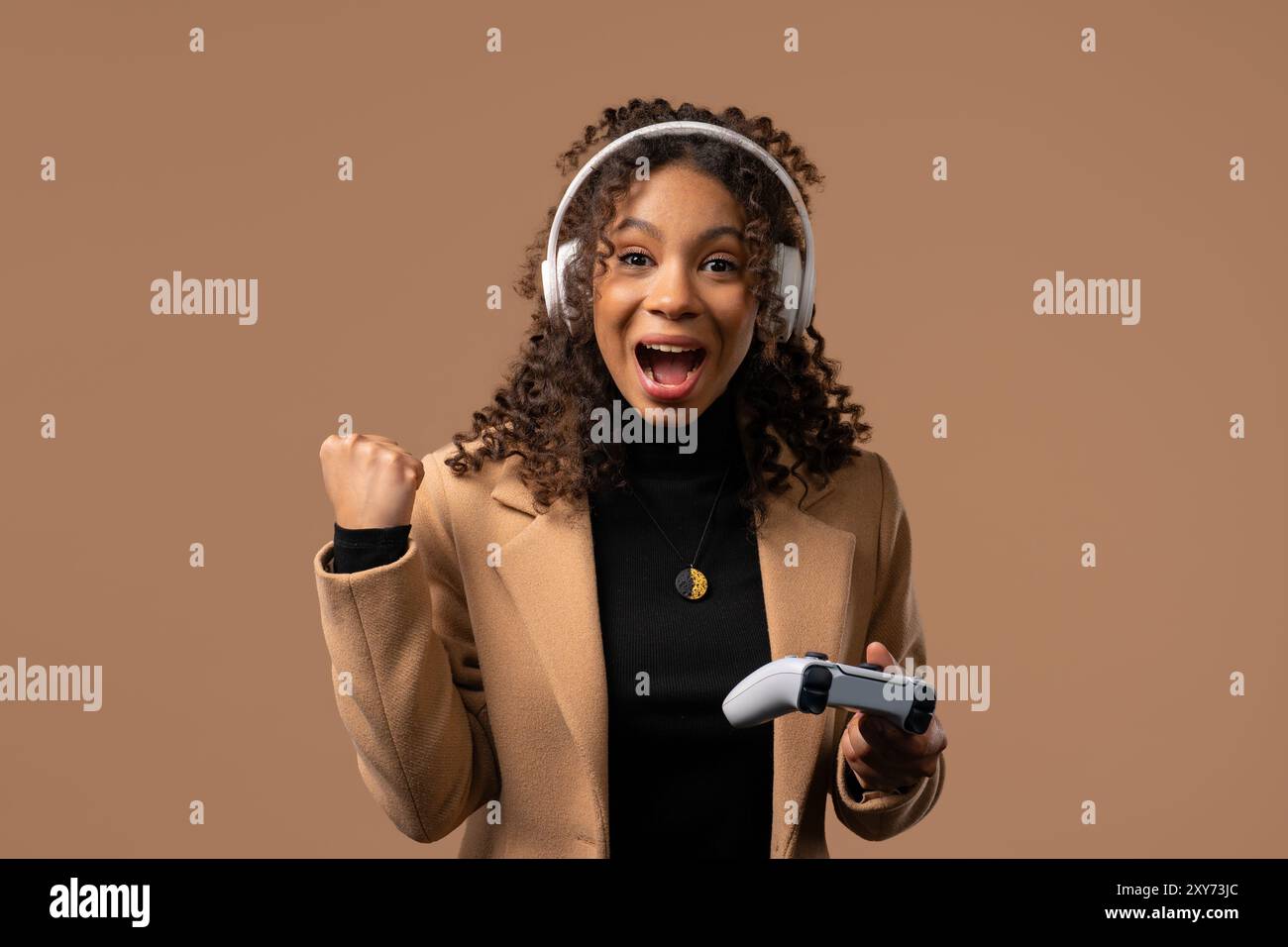 Hübsche junge Frau, die ein aufregendes Videospiel im Fernsehen mit Joystick auf rosa Studiohintergrund spielt. Mit moderner Technologie. E-Sport, Hobby, Stream Stockfoto