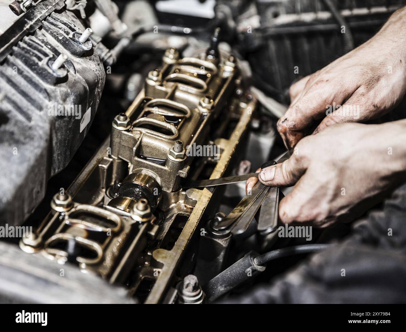 Kfz-Servicemitarbeiter oder Werkstattmechaniker halten ein Fahrzeug-Motorwartungswerkzeug zur Reparatur des Auto-Motors Stockfoto