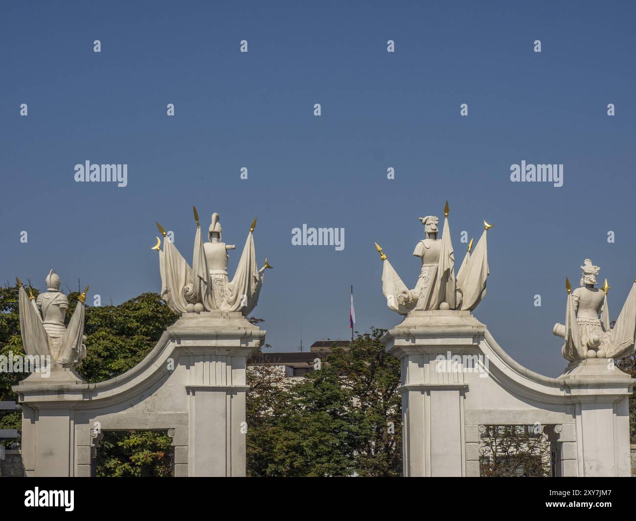 Detaillierte Ansicht von barocken Skulpturen und Dekorationen auf einem weißen Tor vor einem blauen Himmel, bratislava, slowakei Stockfoto