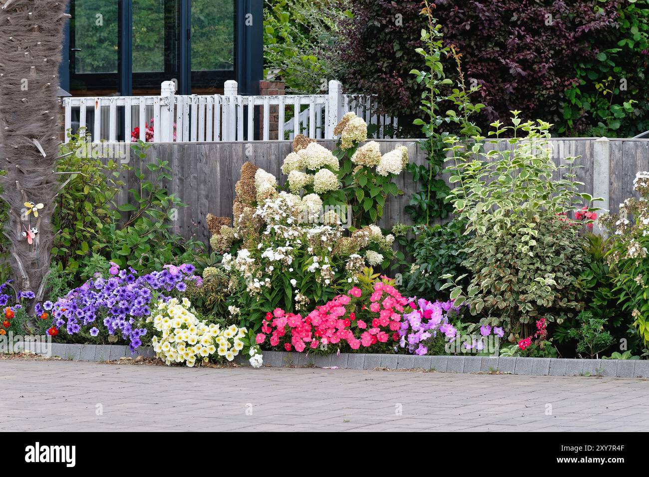 Ein farbenfrohes Blumenbeet auf der Einfahrt eines Wohnhauses in Shepperton Surrey England, Großbritannien Stockfoto
