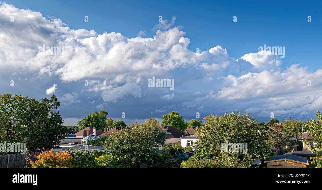 Große Kumulonimbuswolken bilden sich über einer ländlichen Stadtlandschaft Stockfoto
