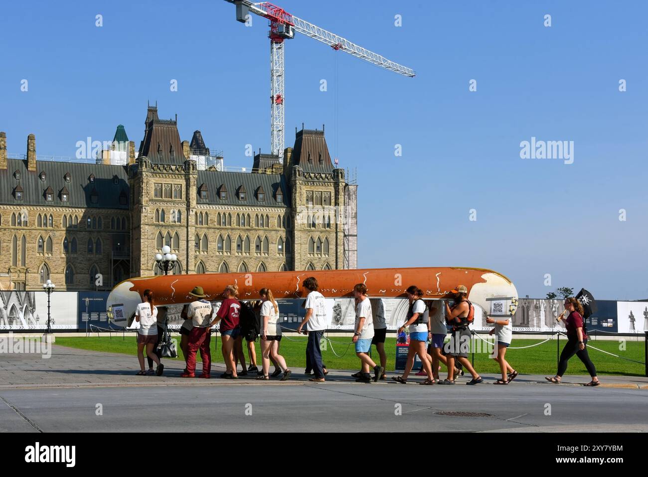 Ottawa, Kanada - 27. August 2024: Eine Gruppe junger Erwachsener trägt ein großes Kanu zum Parliament Hill, um Geld für wohltätige Zwecke zu sammeln. Stockfoto