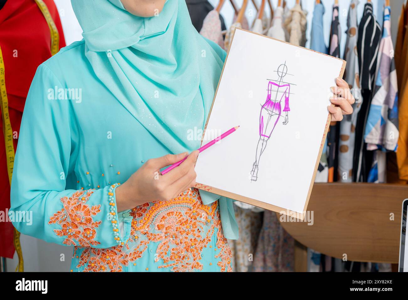 Der Besitzer eines kleinen Schneidergeschäfts stellt Kleidungsstücke vor Stockfoto