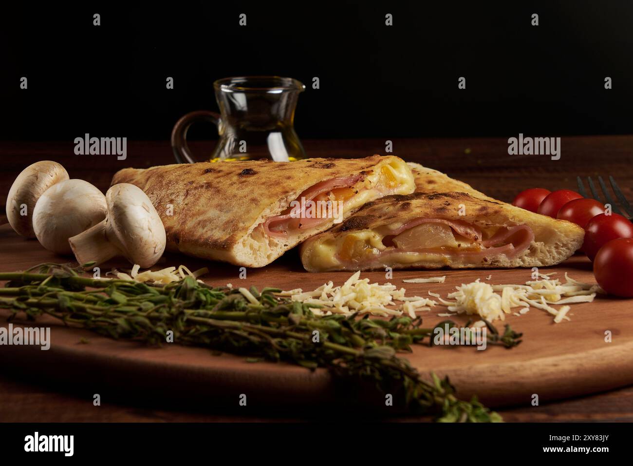 Calzone, traditionelle italienische Zubereitung, begleitet von Gewürzen und Rotwein Stockfoto