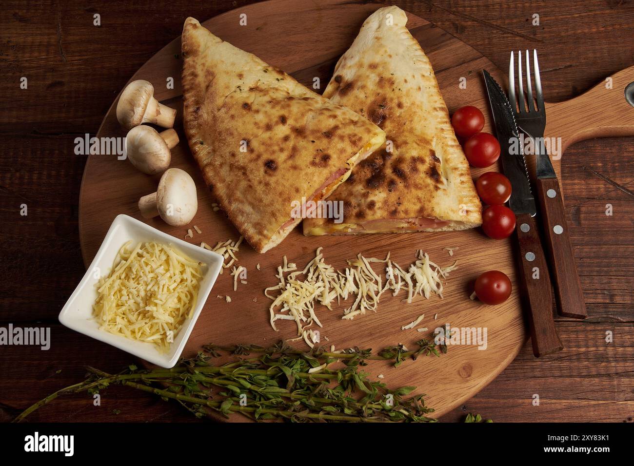 Calzone, traditionelle italienische Zubereitung, begleitet von Gewürzen und Rotwein Stockfoto