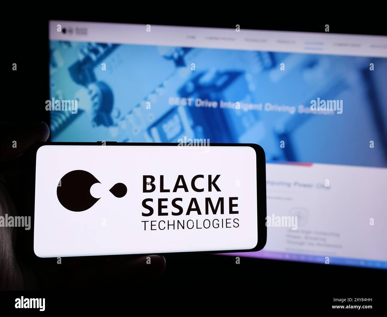 Person mit Smartphone und Logo des Automobilsoftwareunternehmens Black Sesame Technologies vor der Website. Schwerpunkt auf dem Display des Telefons. Stockfoto