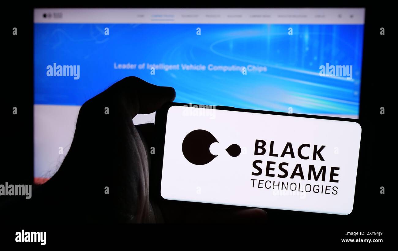 Person, die ein Mobiltelefon mit dem Logo des Automobilsoftwareunternehmens Black Sesame Technologies vor der Webseite hält. Schwerpunkt auf dem Display des Telefons. Stockfoto