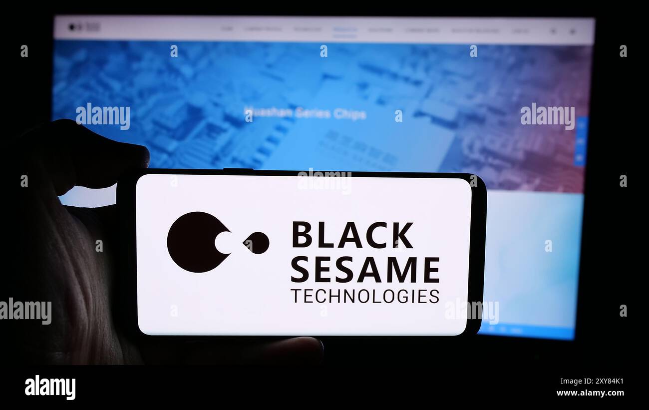 Person, die ein Mobiltelefon mit dem Logo des Automobilsoftwareunternehmens Black Sesame Technologies vor der Unternehmenswebseite hält. Schwerpunkt auf dem Display des Telefons. Stockfoto
