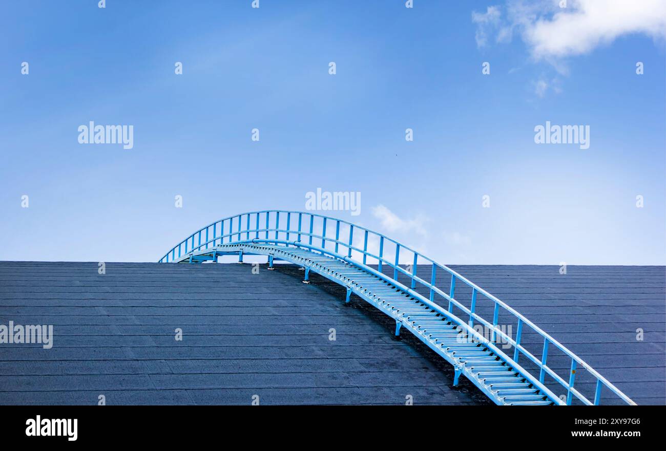 Treppe auf dem Dach und vor dem Hintergrund des blauen Himmels und der Wolken Stockfoto