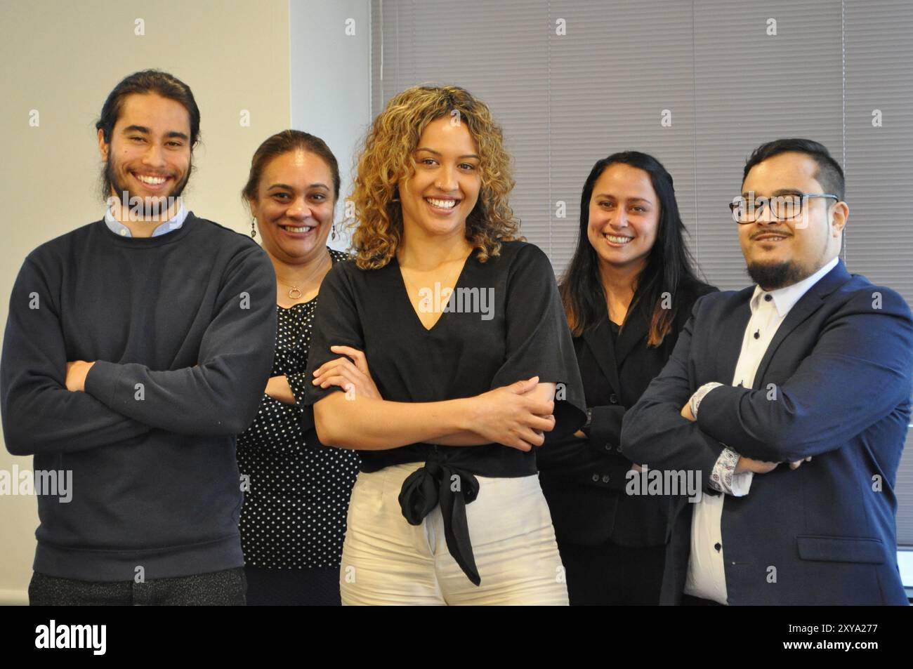 Weibliche Anführerin eines Teams hinter ihr aus Māori und pazifikinseln Stockfoto