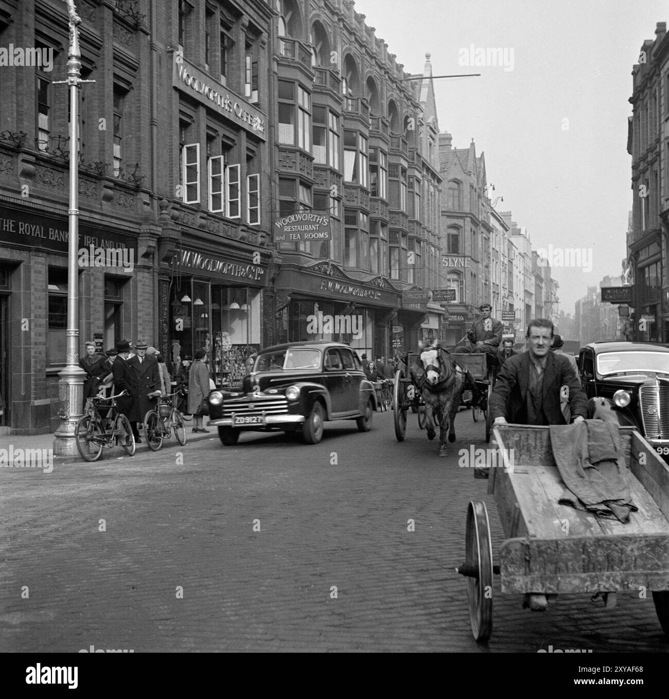 Irisches Vintage-Foto, Grafton Street, Dublins Hauptstraße, 1946, verschiedene Verkehrsmittel, Autos, Wagen, Pferde gezeichnet, Menschen Stockfoto