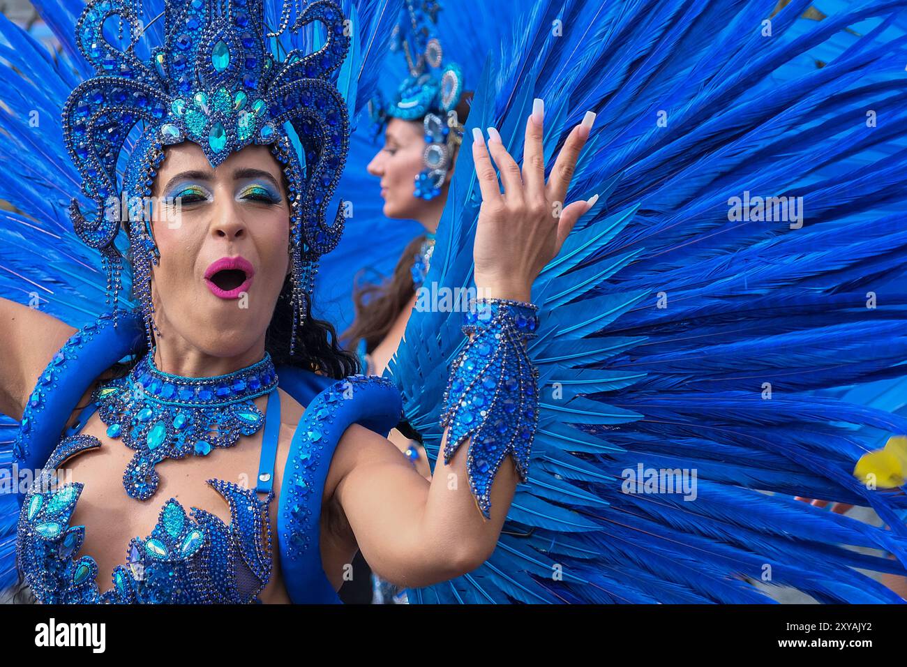 London, Großbritannien. Am Haupttag des Notting Hill Carnival, auch bekannt als Erwachsenentag, werden die Teilnehmer in farbenfrohen und raffinierten Kostümen umarmt. Stockfoto