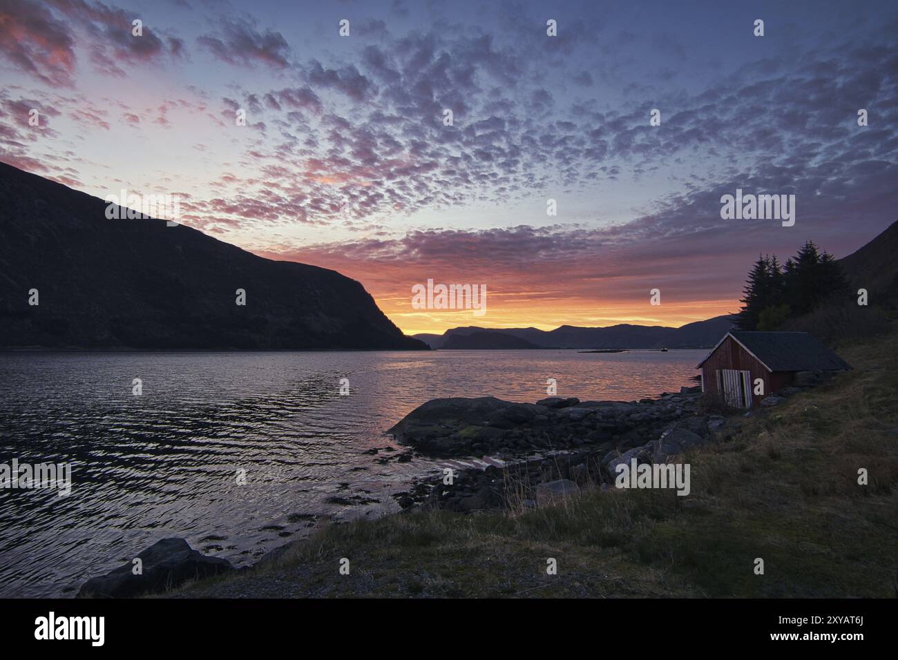 Sonnenuntergang auf dem Fjord von Selje Norwegen. Sehr schöne Farben spiegeln sich in den Wolken und dem Wasser. Angelurlaub in fantastischer Landschaft Stockfoto