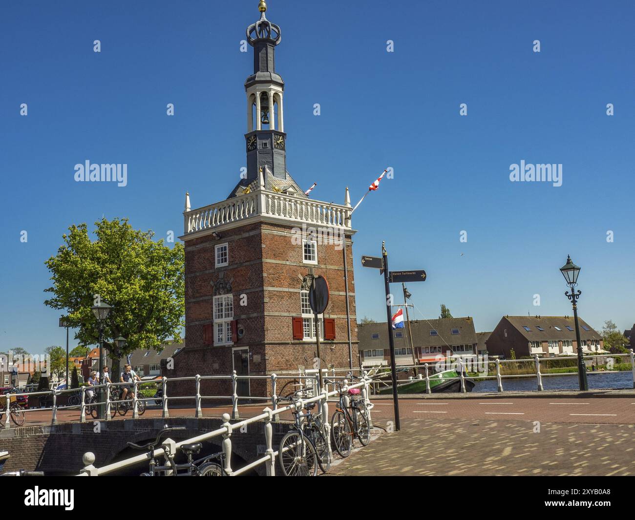 Historisches Gebäude am Kanal mit Fahrrädern im Vordergrund und klarem, sonnigem Himmel, alkmaar, niederlande Stockfoto