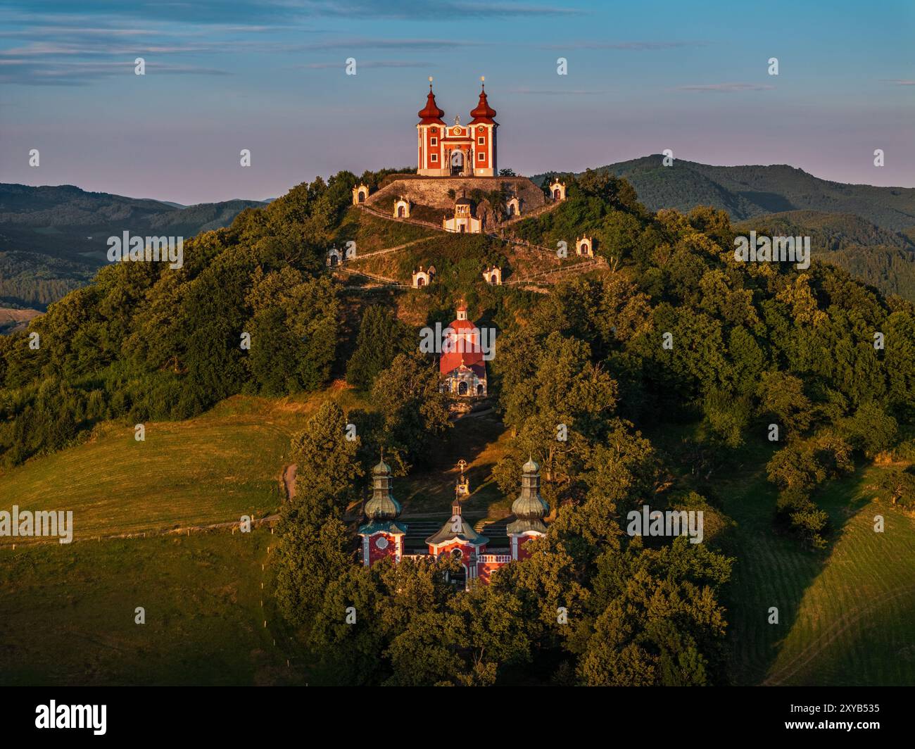 Banska Stiavnica, Slowakei - aus der Vogelperspektive auf den wunderschönen barocken Kalvarienkalvaria in der Slowakei bei Sonnenuntergang an einem Sommernachmittag mit klarem blauen Himmel im Hintergrund Stockfoto