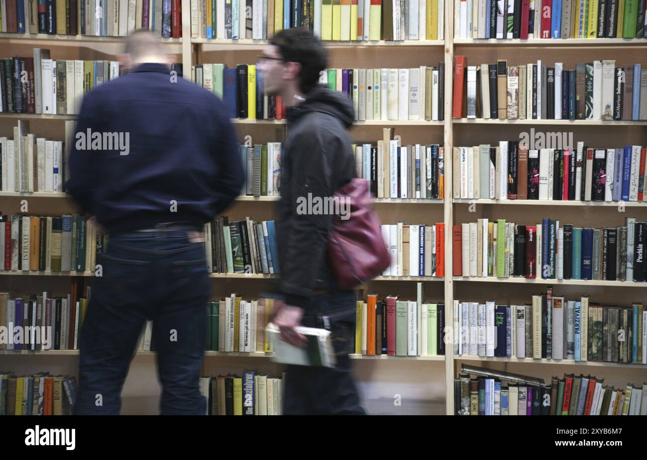 Leute vor vollen Bücherregalen Stockfoto